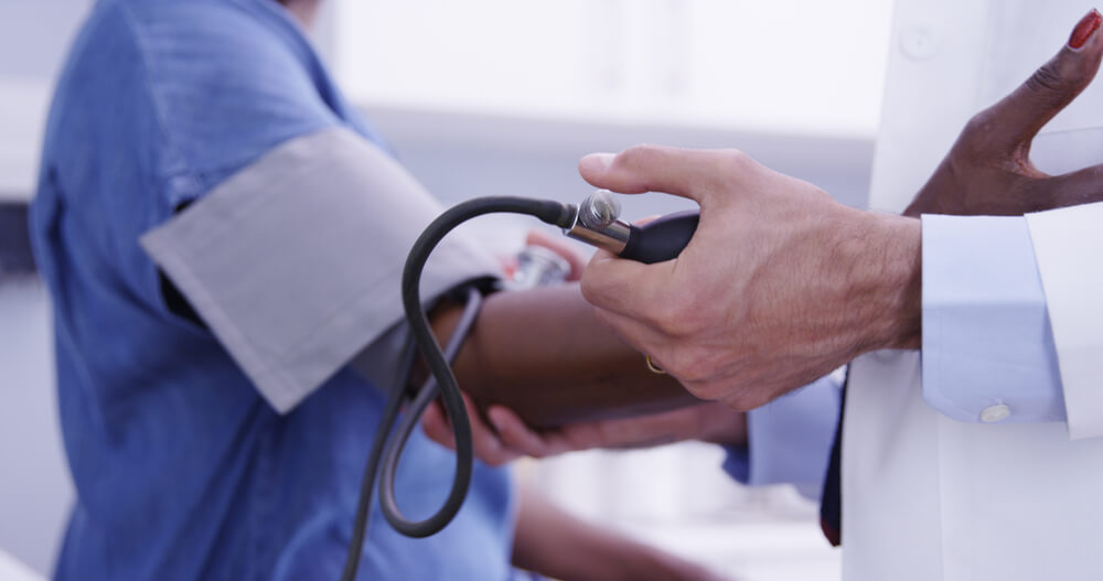  Young MD Checking Senior Womans Blood Pressure With Stethoscope