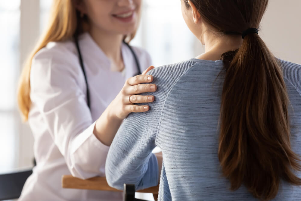 Supportive Female Nurse Touch Patient Arm Show Empathy and Care at Appointment