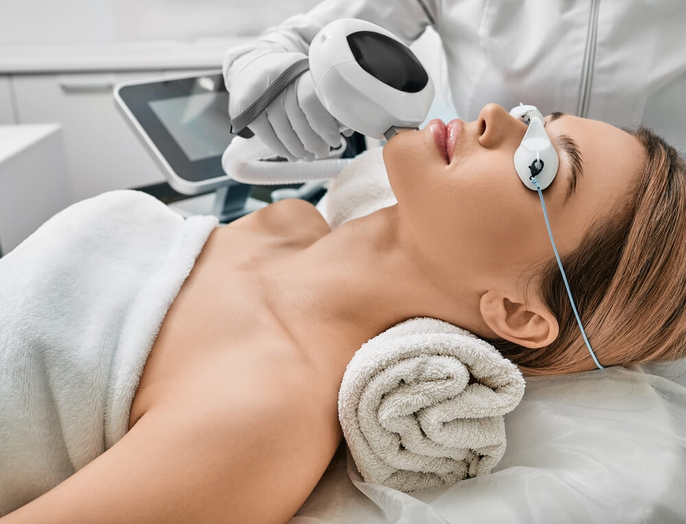 Photorejuvenation, Rosacea Treatment, Removing Brown Spots and Vascular Mesh. Cosmetologist Using Ipl Apparatus Treats Skin of Female Patient’s Face