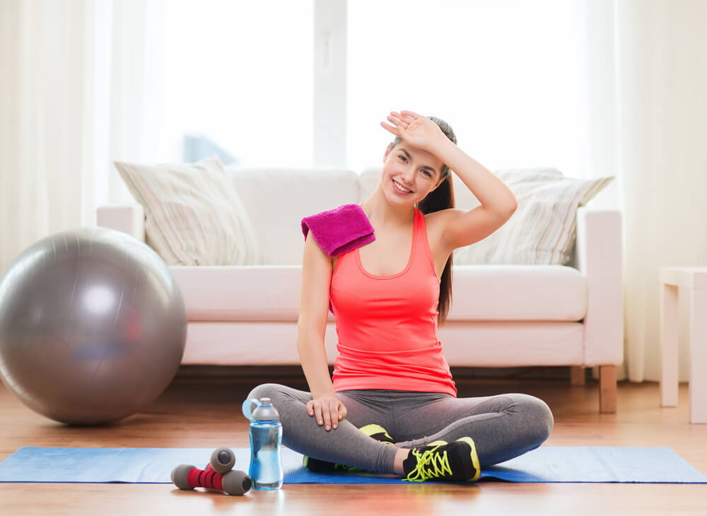 Fitness, Home and Diet Concept - Smiling Girl With Bottle of Water After Exercising at Home