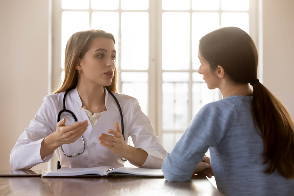 Female Physician in Charge Receiving Consulting Young Woman Patient
