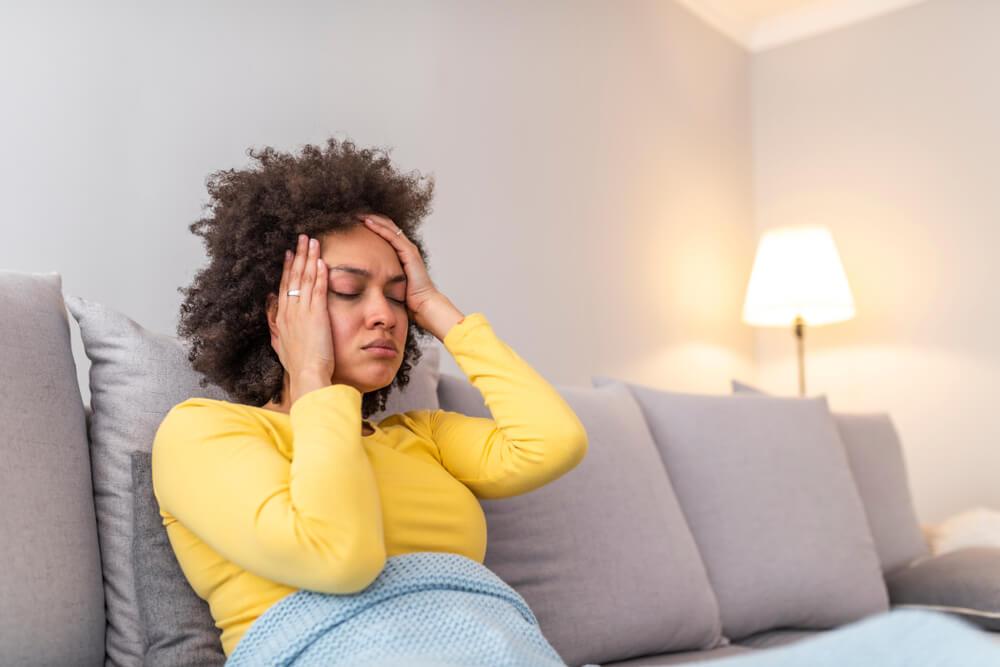 Woman Suffering From Stress or a Headache Grimacing in Pain.