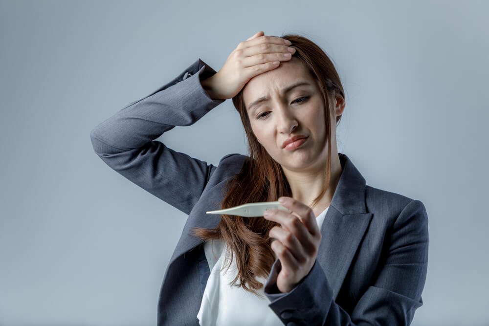 Woman Using Clinical Electronic Thermometer.