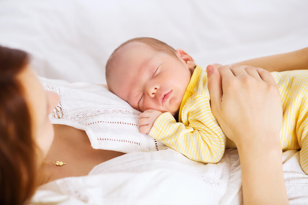 Newborn Sleeping Child in the Hands of Mother
