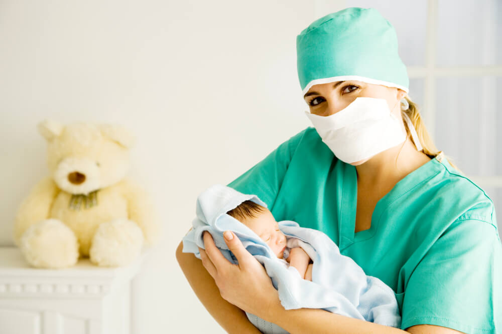 A Medical Practitioner Holding a Newborn Baby