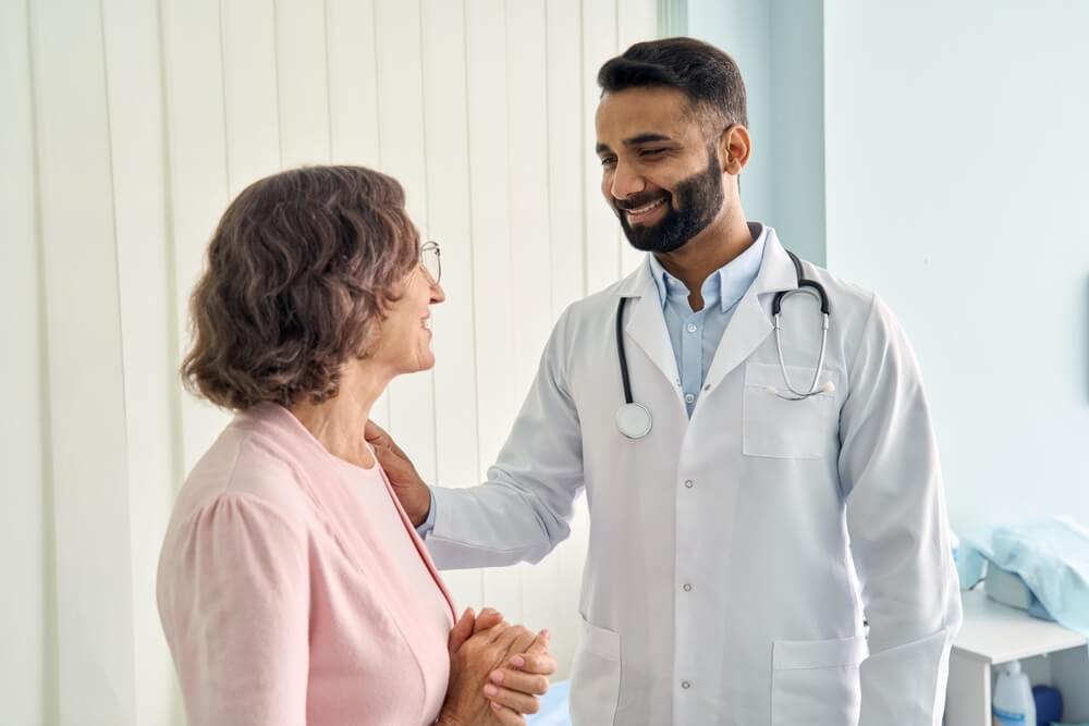 Happy Young Indian Doctor Therapist in White Coat Has Appointment Consulting