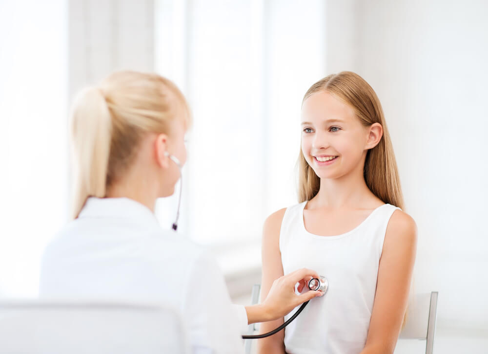 Female Doctor Using Stethoscope to Examine a Young Girl