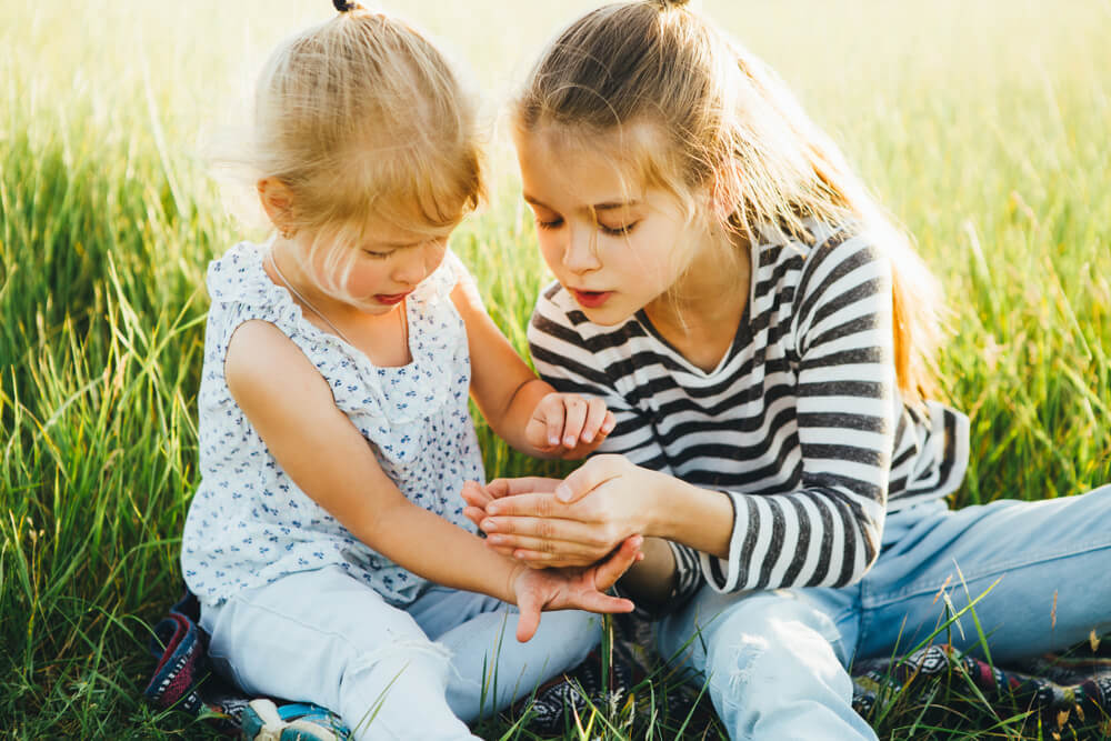 Two Young Girls Sitting in the Field