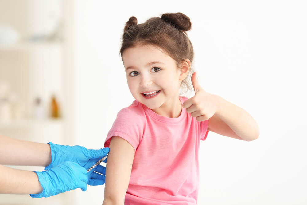 Doctor vaccinating cute little girl in clinic