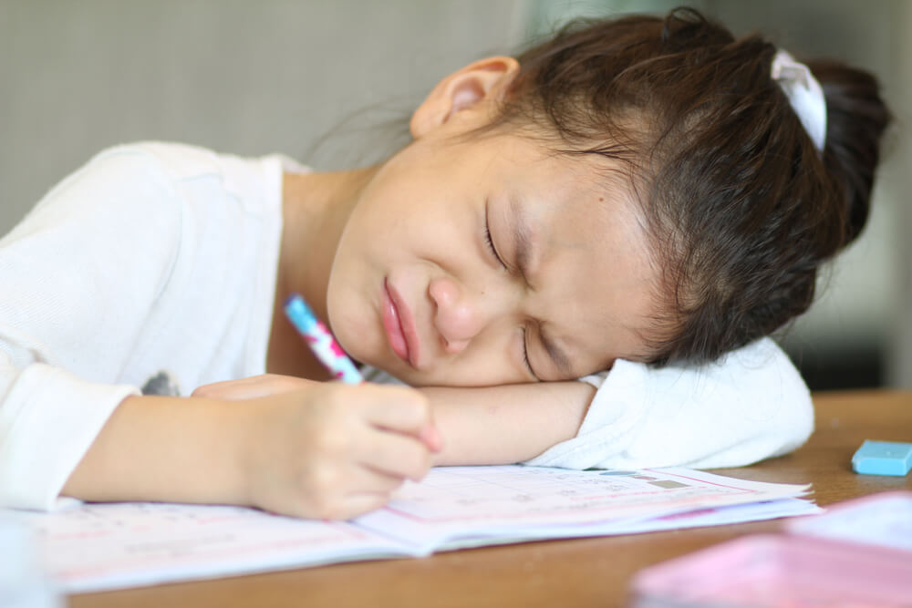 Preschool Asian Little Girl Crying or Unhappy While Doing Homework or Boring in Her Studying, or in Trouble.