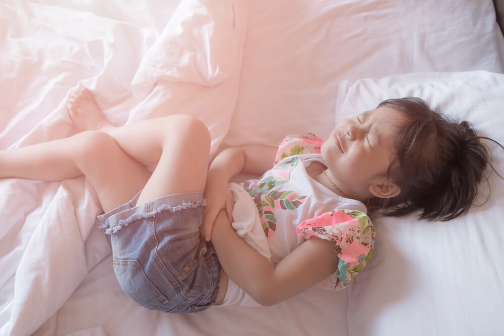 A Little Girl in Her Bed Has a Stomachache