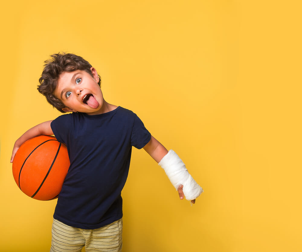 Funny Kittle Boy With Broken Arm With Basketball Isolated on Yellow.