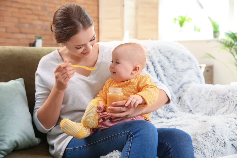 Mother Feeding Her Little Baby at Home