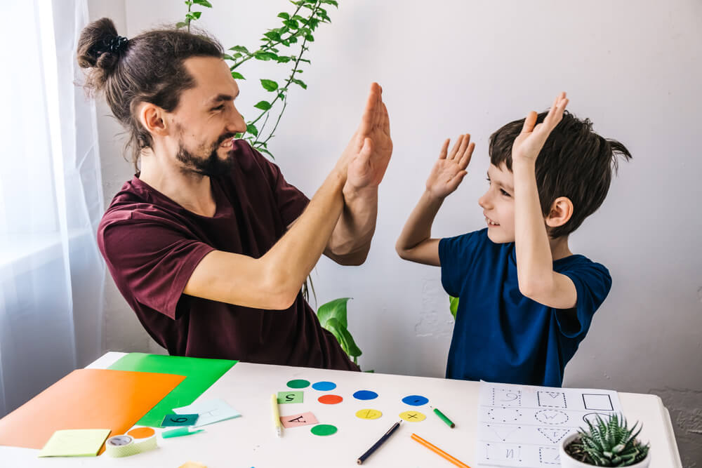 Happy Autism Boy During Therapy With School Tutor, Learning and Having Fun Together