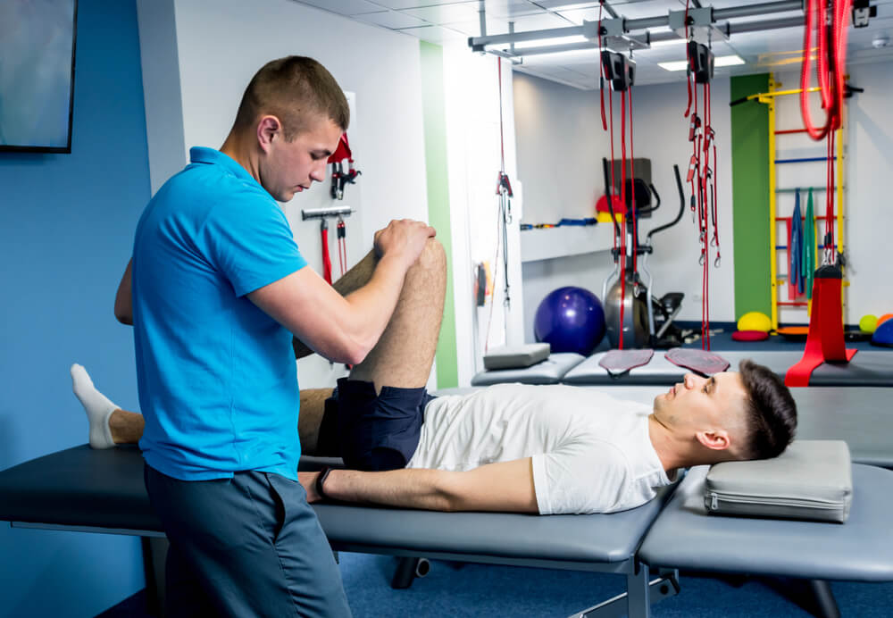 Physiotherapist Working With Young Male Patient in the Rehabilitation Center.