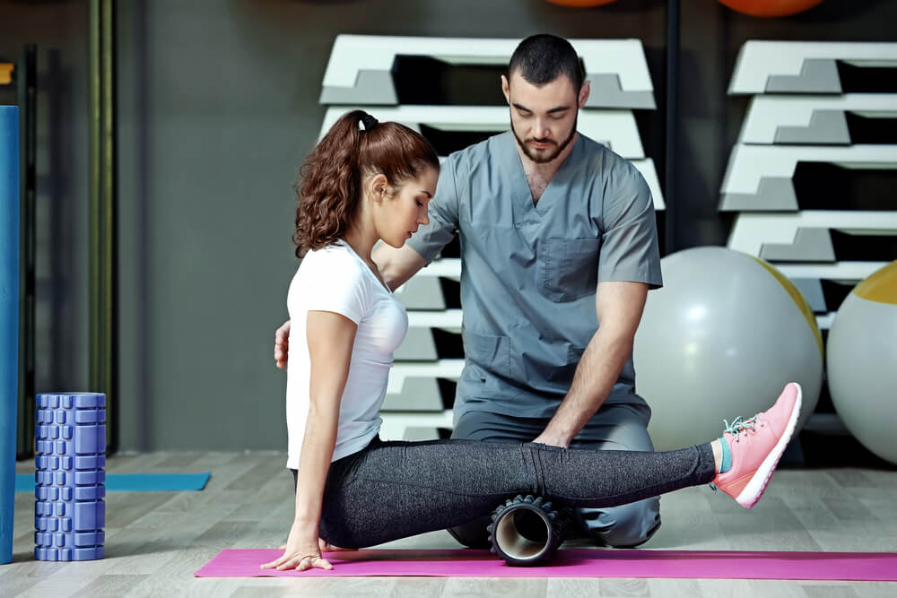 Young Woman Doing Exercises Under Physiotherapist Supervision