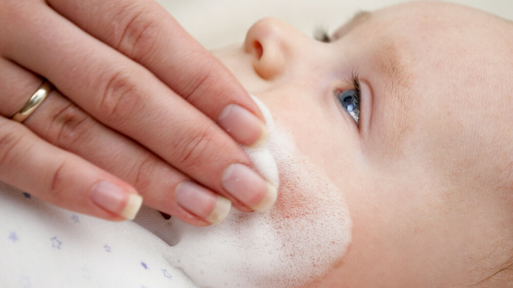 Closeup of Mother Applying Medical Ointment for Curing Baby Dermatitis and Acne