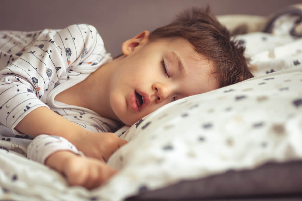 Little Blond Boy Sleeping in His Bed.