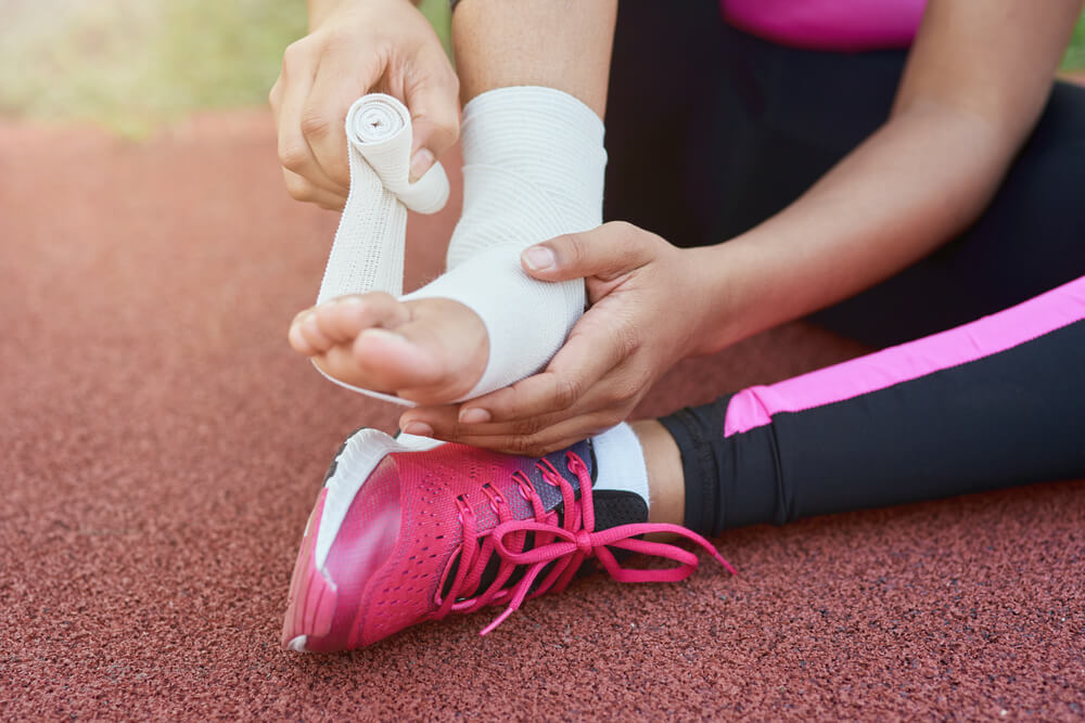 A Girl Putting Bandage on Injured Foot