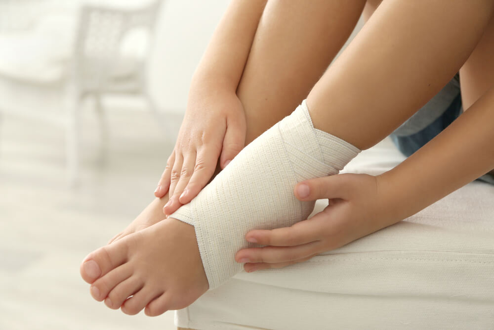 Little Girl Touching Ankle With Elastic Bandage