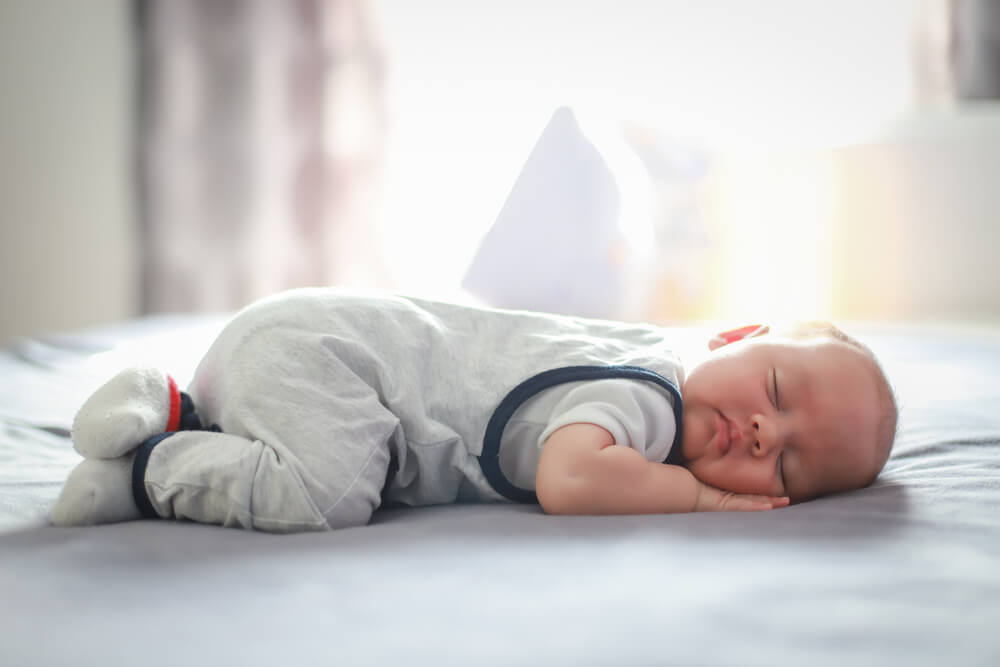 Cute Newborn Baby About Two Months Old Sleep on Stomach on Bed at Home