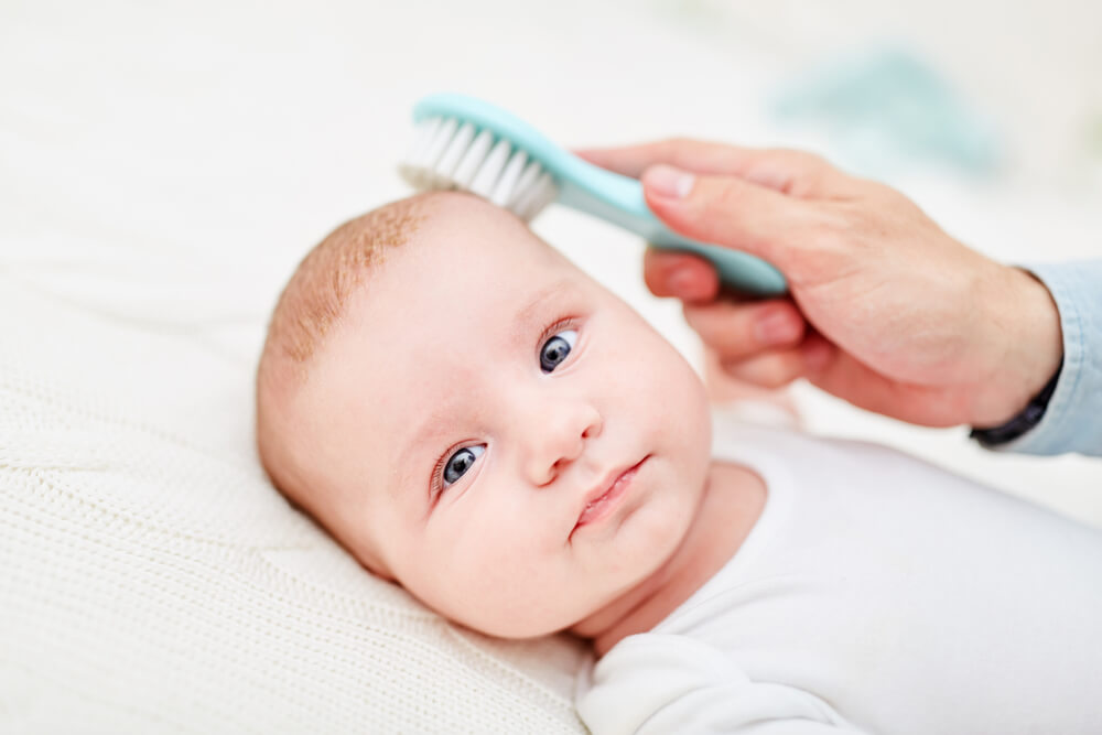 Brush Removes Dandruff From the Skin of a Newborn Baby