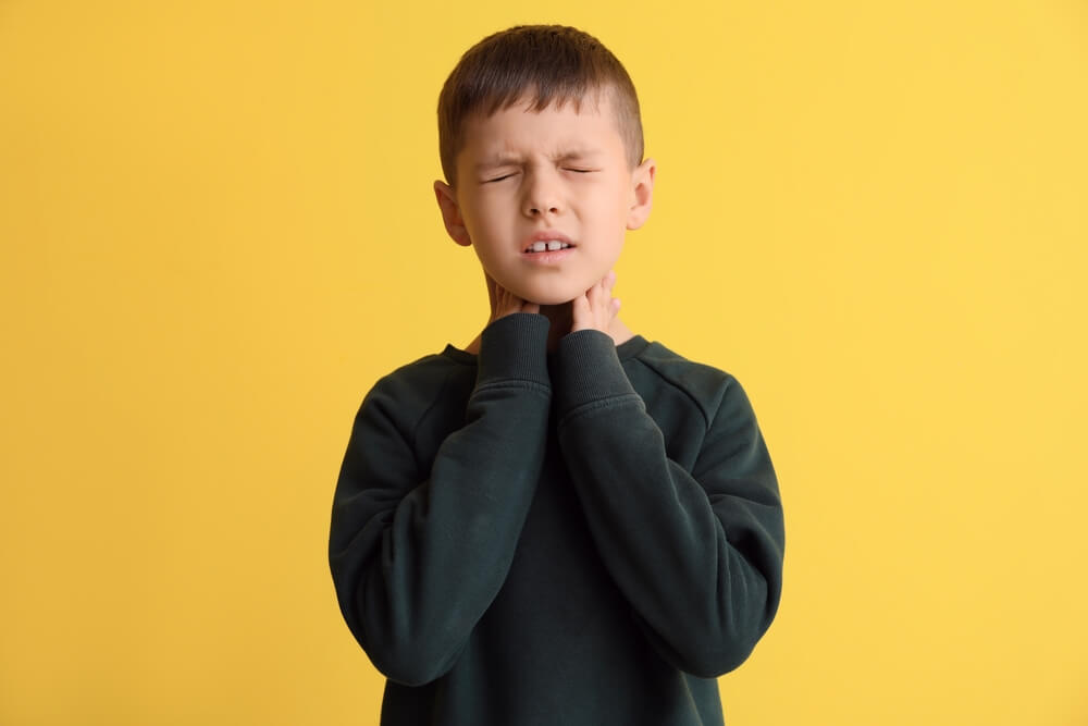 Ill Little Boy With Sore Throat on Color Background