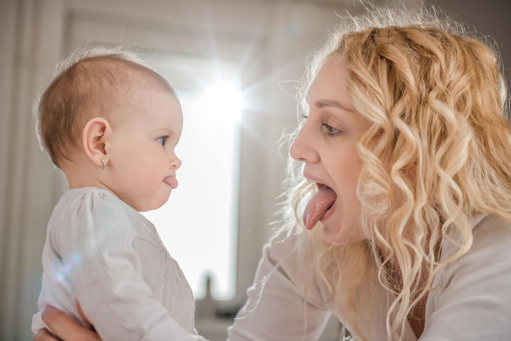 Mother and her baby with tongue sticking out