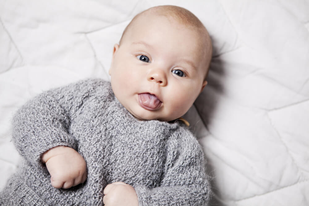 Close up of a 3 month old baby sticking her tongue out