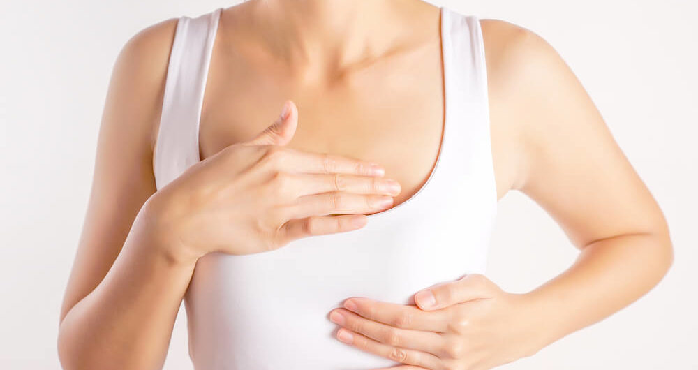 Woman Wearing a White Tank Top Checking Her Breast