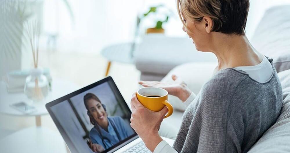 A Woman With Laptop During an Online Consultation With Her Doctor in Her Living Room