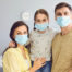 Family in Medical Masks on the Face Standing in the Room at Home
