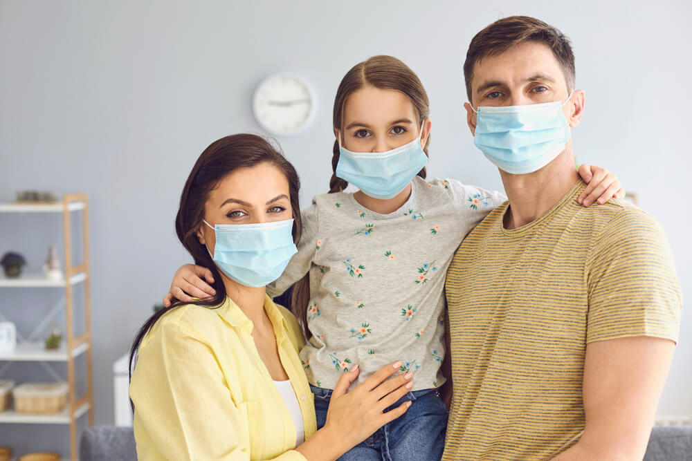 Family in Medical Masks on the Face Standing in the Room at Home